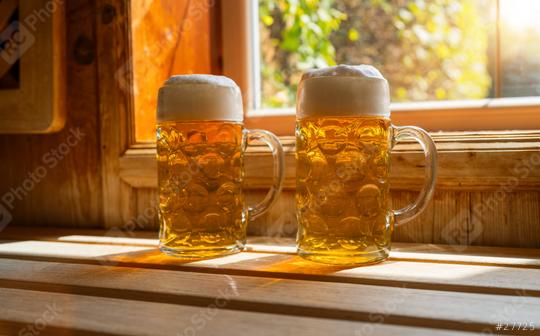 Two beer mugs with frothy beer rest on a ledge, catching sunlight. spa and wellness concept image  : Stock Photo or Stock Video Download rcfotostock photos, images and assets rcfotostock | RC Photo Stock.: