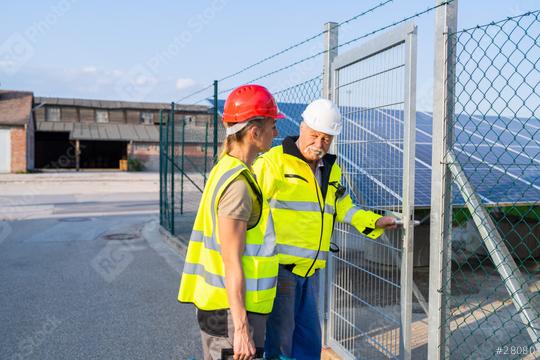 Two engineers in high-visibility vests inspect a solar panel field going in on a facility gate  : Stock Photo or Stock Video Download rcfotostock photos, images and assets rcfotostock | RC Photo Stock.: