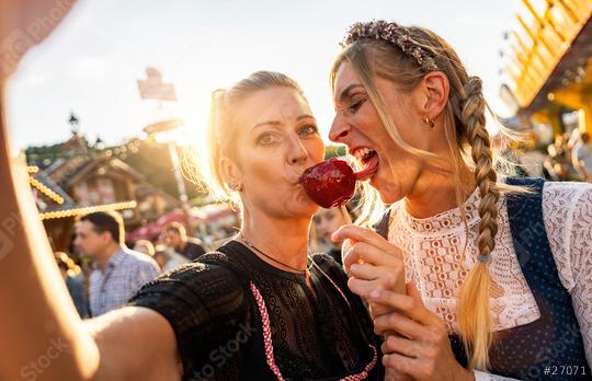 Two friends making selfie wearing dirndl and holding candy apples at a Bavarian fair or oktoberfest or duld in national costume or Dirndl  : Stock Photo or Stock Video Download rcfotostock photos, images and assets rcfotostock | RC Photo Stock.:
