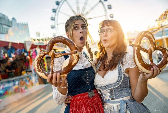Two happy girlfriends together on a Bavarian fair or oktoberfest or duld in national costume or Dirndl with  pretzel or brezen in germany  : Stock Photo or Stock Video Download rcfotostock photos, images and assets rcfotostock | RC Photo Stock.: