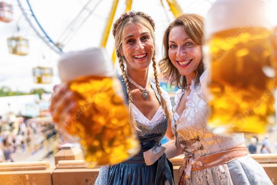 Two happy women in traditional Bavarian outfits or tracht cheerfully toasting with beer mugs at oktoberfest or duld in a fair germany  : Stock Photo or Stock Video Download rcfotostock photos, images and assets rcfotostock | RC Photo Stock.: