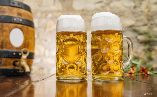 Two mugs of beer with foam stand on the table with wooden barrel  : Stock Photo or Stock Video Download rcfotostock photos, images and assets rcfotostock | RC Photo Stock.: