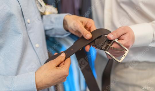 Two people examining a leather belt with a metal buckle  : Stock Photo or Stock Video Download rcfotostock photos, images and assets rcfotostock | RC Photo Stock.: