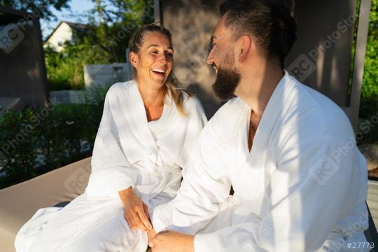 Two people in white robes sitting on a couple