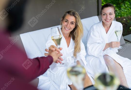 Two women in white bathrobes receiving champagne glasses from a waiter in a spa hotel  : Stock Photo or Stock Video Download rcfotostock photos, images and assets rcfotostock | RC Photo Stock.: