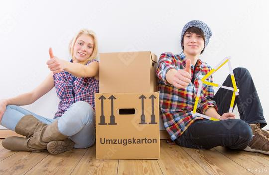 Two young people sitting on a wooden floor with moving boxes, smiling and giving thumbs up, with a measuring tool shaped like a house symbolizing a new home
  : Stock Photo or Stock Video Download rcfotostock photos, images and assets rcfotostock | RC Photo Stock.: