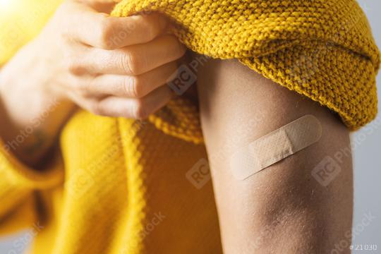vaccine injection for corona COVID-19 and SARS cov . Woman holding up her sweater sleeve and showing her arm with Adhesive bandage Plaster after receiving vaccination  : Stock Photo or Stock Video Download rcfotostock photos, images and assets rcfotostock | RC Photo Stock.:
