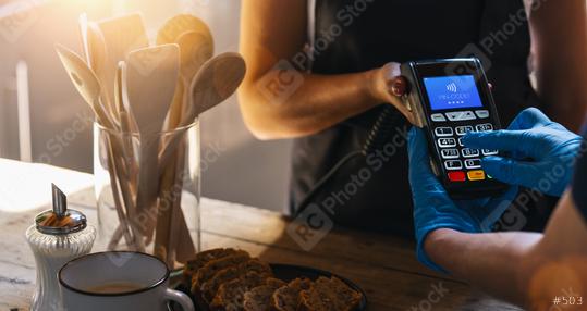Waiter holding credit card swipe machine while customer with gloves typing Pin-code. Woman making payment in cafeteria with credit card. Customer paying for coffee and brunch by credit card reader.  : Stock Photo or Stock Video Download rcfotostock photos, images and assets rcfotostock | RC-Photo-Stock.: