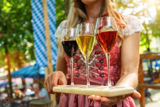 Waitress carries different types of wine in glasses through a Bavarian beer garden or oktoberfest  : Stock Photo or Stock Video Download rcfotostock photos, images and assets rcfotostock | RC Photo Stock.: