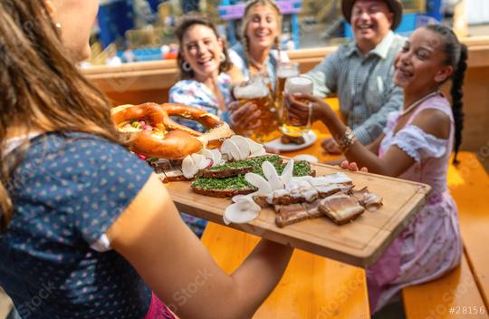 Waitress serving a wooden platter of traditional German food to a group of joyful people in a beer tent at oktoberfest festival or dult in germany  : Stock Photo or Stock Video Download rcfotostock photos, images and assets rcfotostock | RC Photo Stock.: