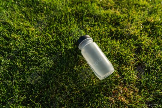 Water bottle lying on the grass in sunlight. Sports gear concept image  : Stock Photo or Stock Video Download rcfotostock photos, images and assets rcfotostock | RC Photo Stock.: