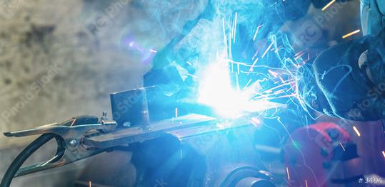 welder welds a metal piece and sparks from welding fly in different directions  : Stock Photo or Stock Video Download rcfotostock photos, images and assets rcfotostock | RC Photo Stock.: