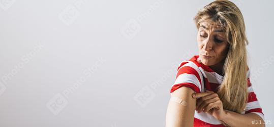 woman after getting a vaccine injection for Covid-19. Woman holding up her shirt sleeve and showing her arm with Adhesive bandage Plaster after receiving vaccination, copyspace for your individual   : Stock Photo or Stock Video Download rcfotostock photos, images and assets rcfotostock | RC Photo Stock.: