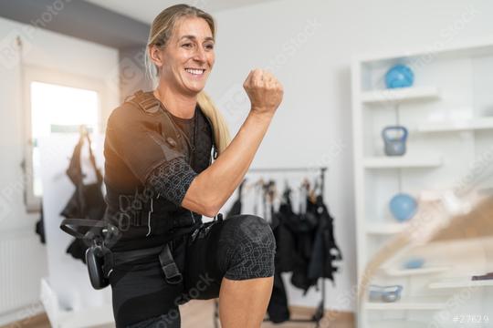 woman doing squats in an EMS suit during a workout session in EMS-Studio  : Stock Photo or Stock Video Download rcfotostock photos, images and assets rcfotostock | RC Photo Stock.: