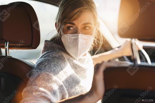 Woman driving car with a N95 FFP2 anti virus mask, protective mask against coronavirus, driver on a city street looking back, check behind going reverse during a coronavirus outbreak, covid-19.  : Stock Photo or Stock Video Download rcfotostock photos, images and assets rcfotostock | RC Photo Stock.: