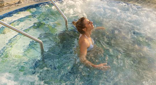 Woman enjoying a soak in a hot tub, surrounded by bubbling water and a pool railing  : Stock Photo or Stock Video Download rcfotostock photos, images and assets rcfotostock | RC Photo Stock.: