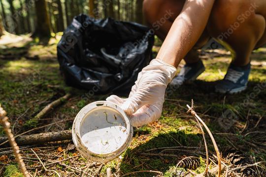 woman hand picking up a lid from a coffee to go cup for cleaning the forest from plastic garbage, nature and environment cleaning concept image.  : Stock Photo or Stock Video Download rcfotostock photos, images and assets rcfotostock | RC Photo Stock.: