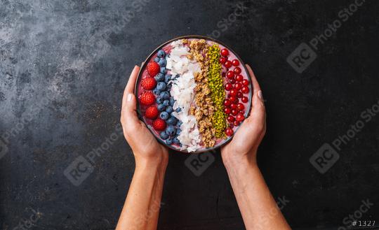 Woman hands hold a Healthy breakfast bowl, wirh blueberry smoothie with, raspberry, blueberrys, coconut, nuts and currants toppings  : Stock Photo or Stock Video Download rcfotostock photos, images and assets rcfotostock | RC Photo Stock.: