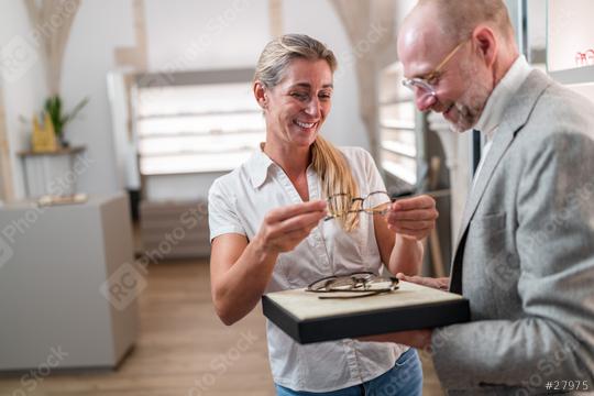 Woman happily trying on glasses with optician presenting eyewear options. Optical store interior in the background.  : Stock Photo or Stock Video Download rcfotostock photos, images and assets rcfotostock | RC Photo Stock.: