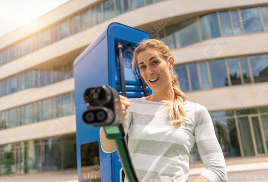 woman holding a DC CCS2 EV charging connector on a Hypercharger   : Stock Photo or Stock Video Download rcfotostock photos, images and assets rcfotostock | RC Photo Stock.: