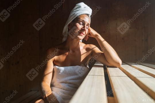 Woman in a finnish sauna leaning back, eyes closed, with a towel wrapped around her head, sunlit at a spa resort  : Stock Photo or Stock Video Download rcfotostock photos, images and assets rcfotostock | RC Photo Stock.: