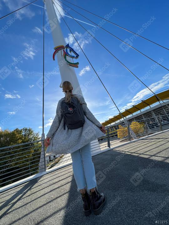 woman in a gray cardigan and jeans stands on a bridge, looking up at a colorful horse emblem on a pole, with a blue sky and a modern bridge with chio sign in the background
  : Stock Photo or Stock Video Download rcfotostock photos, images and assets rcfotostock | RC Photo Stock.: