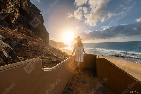 woman in a hat descending beach stairs at sunset, facing the ocean at Playa de Cofete, Fuerteventura, Canary Islands.  : Stock Photo or Stock Video Download rcfotostock photos, images and assets rcfotostock | RC Photo Stock.: