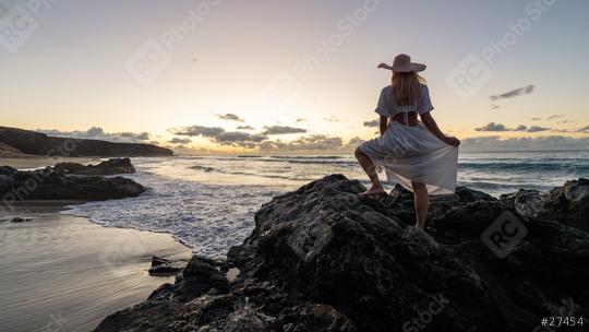 Woman in a white dress and straw hat standing on rocks at the beach during a vibrant sunset  : Stock Photo or Stock Video Download rcfotostock photos, images and assets rcfotostock | RC Photo Stock.: