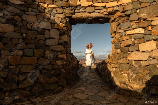 Woman in a white dress and straw hat walking through an ancient stone archway  : Stock Photo or Stock Video Download rcfotostock photos, images and assets rcfotostock | RC Photo Stock.: