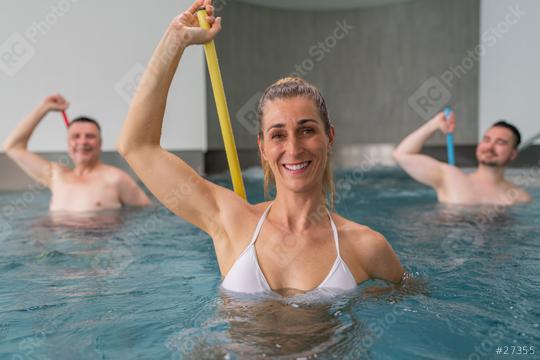 Woman in a white swimsuit leads water aerobics with two men in the background, all using resistance bars. Sports and gymnastics under water in spa resort.  : Stock Photo or Stock Video Download rcfotostock photos, images and assets rcfotostock | RC Photo Stock.: