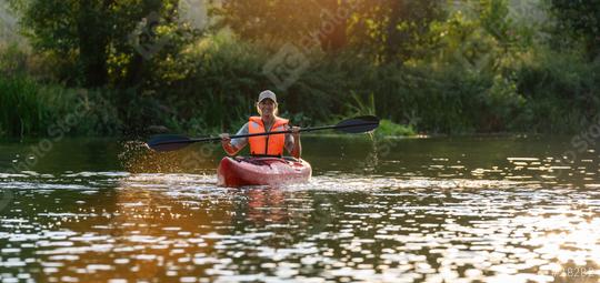 woman in an orange life vest joyfully kayaks on a serene river at sunset, surrounded by lush greenery at summer in germany. Kayak Water Sports concept image  : Stock Photo or Stock Video Download rcfotostock photos, images and assets rcfotostock | RC Photo Stock.: