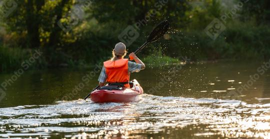 woman in an orange life vest paddles a red kayak on a sunlit river, viewed from behind with water droplets in air. Kayak Water Sports concept image  : Stock Photo or Stock Video Download rcfotostock photos, images and assets rcfotostock | RC Photo Stock.: