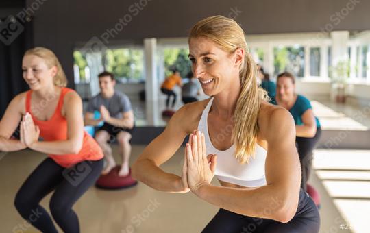 Woman in fitness class performing squats with hands together at a fitness class on Bosu Ball with others in background  : Stock Photo or Stock Video Download rcfotostock photos, images and assets rcfotostock | RC Photo Stock.: