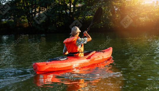 Woman in orange life vest kayaking on a tranquil river with lush greenery at sunset. Kayak Water Sports concept image  : Stock Photo or Stock Video Download rcfotostock photos, images and assets rcfotostock | RC Photo Stock.: