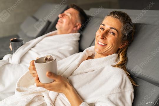 Woman in white robe holding a cup of tea smiling, man behind sipping his tea  : Stock Photo or Stock Video Download rcfotostock photos, images and assets rcfotostock | RC Photo Stock.: