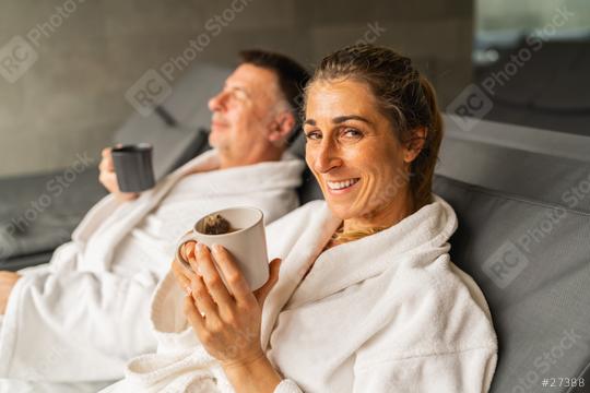 Woman in white robe holding a cup of tea smiling, man behind sipping his tea  : Stock Photo or Stock Video Download rcfotostock photos, images and assets rcfotostock | RC Photo Stock.: