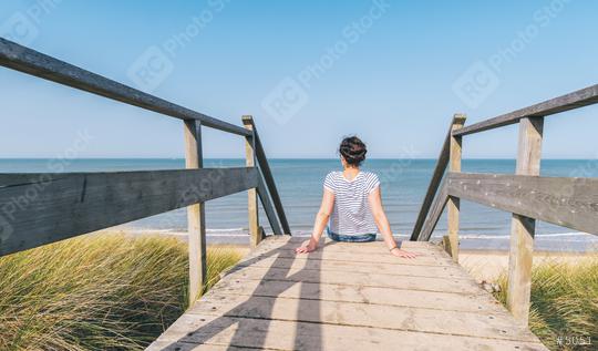 woman ís sitting on a wooden path to the Baltic sea over sand dunes with ocean view  : Stock Photo or Stock Video Download rcfotostock photos, images and assets rcfotostock | RC Photo Stock.: