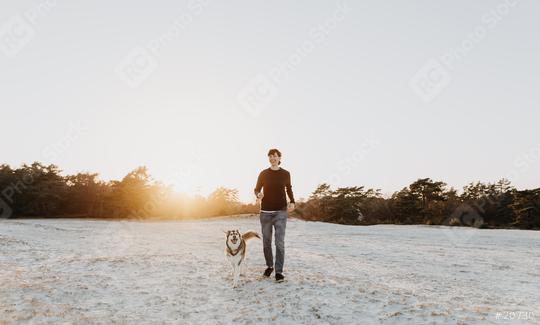 Woman is walking on the sand with his dog on the beach and having fun. Friendship between woman and husky. They are cheerful, happy and enjoy life.  : Stock Photo or Stock Video Download rcfotostock photos, images and assets rcfotostock | RC-Photo-Stock.: