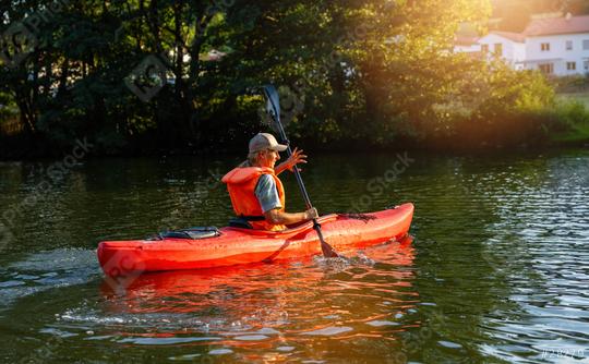 woman joyfully kayaks on a serene river at sunset, surrounded by lush greenery at summer in germany. Kayak Water Sports concept image  : Stock Photo or Stock Video Download rcfotostock photos, images and assets rcfotostock | RC Photo Stock.: