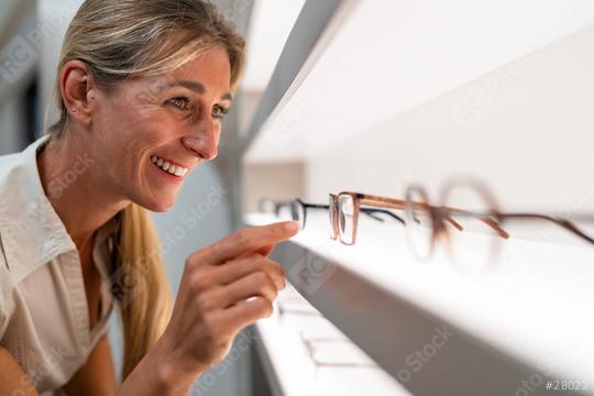 Woman looks at different models of glasses at an optical store on a shelf.  : Stock Photo or Stock Video Download rcfotostock photos, images and assets rcfotostock | RC Photo Stock.: