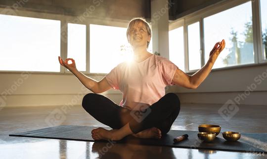 Woman meditating in gym with singing bowls, sunlight, peaceful yoga practice  : Stock Photo or Stock Video Download rcfotostock photos, images and assets rcfotostock | RC Photo Stock.: