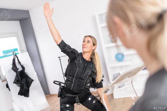 Woman performing exercise in EMS suit with a trainer overseeing in a gym  : Stock Photo or Stock Video Download rcfotostock photos, images and assets rcfotostock | RC Photo Stock.: