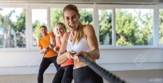 woman pulls on a rope with expressive shout as tug of war competition in a group as teambuilding exercise. Gym for fitness exercises concept image, banner size  : Stock Photo or Stock Video Download rcfotostock photos, images and assets rcfotostock | RC Photo Stock.: