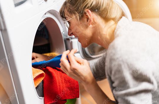 Woman putting clothes out washing machine or dryer, home laundry service, daily routine  : Stock Photo or Stock Video Download rcfotostock photos, images and assets rcfotostock | RC Photo Stock.: