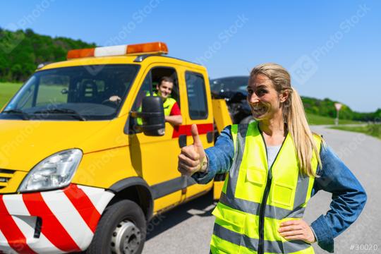 Woman showing thumbs up after a car breakdown with tow truck and driver in background. Roadside assistance concept image.  : Stock Photo or Stock Video Download rcfotostock photos, images and assets rcfotostock | RC Photo Stock.:
