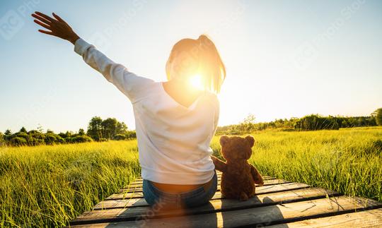 Woman sit on a boardwalk and holding a teddy bear toy at sunset, copyspace for your individual text.  : Stock Photo or Stock Video Download rcfotostock photos, images and assets rcfotostock | RC Photo Stock.: