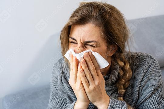 Woman sneezing in a tissue in the living room. Flu, Medicine and healthcare concept image  : Stock Photo or Stock Video Download rcfotostock photos, images and assets rcfotostock | RC Photo Stock.: