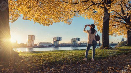 Woman takes a picture from the Skyline of Cologne at autumn  : Stock Photo or Stock Video Download rcfotostock photos, images and assets rcfotostock | RC Photo Stock.: