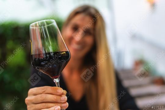 Woman toasting with a glass of red wine, blurred background  : Stock Photo or Stock Video Download rcfotostock photos, images and assets rcfotostock | RC Photo Stock.: