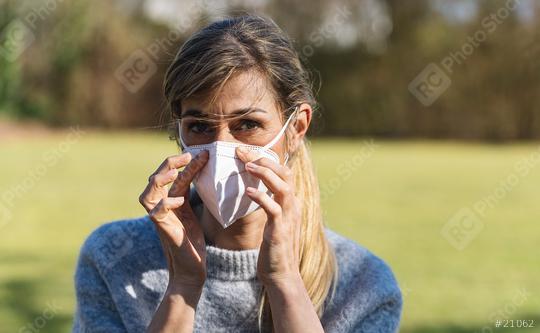 Woman wearing N95 FFP2 an anti virus protection mask to prevent others from coronavirus COVID-19 and SARS cov 2 infection in a park at spring.   : Stock Photo or Stock Video Download rcfotostock photos, images and assets rcfotostock | RC Photo Stock.:
